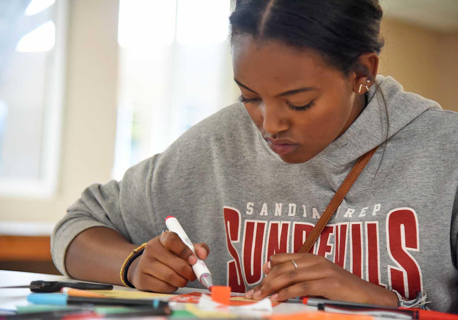 Student works on activity with marker 