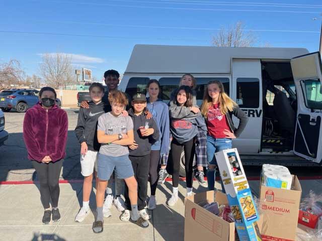 Students pose with items gathered for PB&J Family Services.